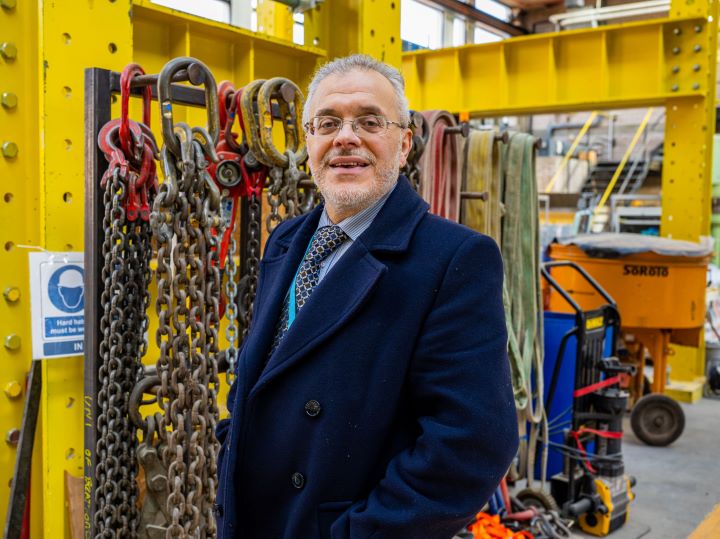 A photo of an academic in a suit from waist height upwards